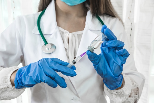 Verpleegkundige vult spuit met medicijn uit ampul