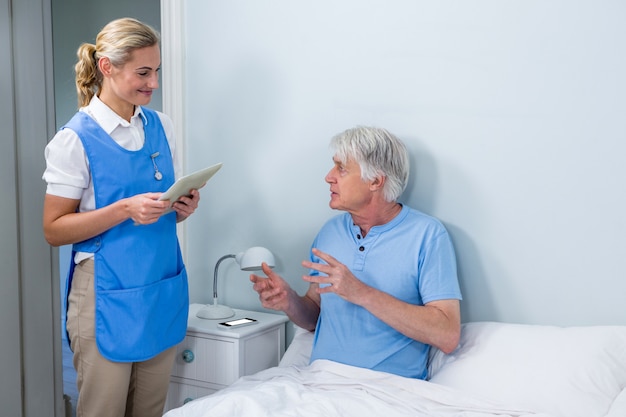 Verpleegster die digitale tablet houdt bij het ziekenhuis