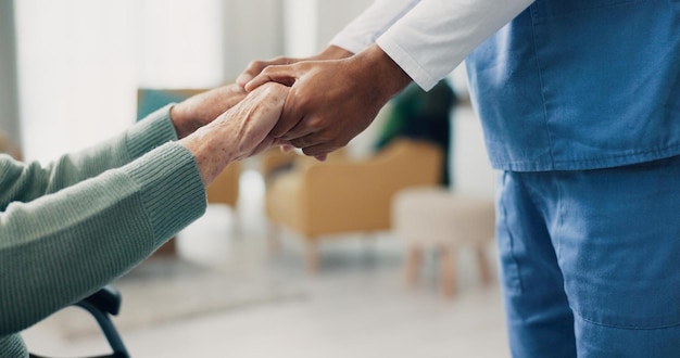 Foto verpleegster voor oudere patiënten en hand in hand in close-up voor ondersteuning, hulp en herstel bij pensionering fysiotherapeutische zorg en oudere persoon met een handicap in rolstoel in de kliniek voor rehabilitatie