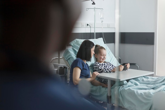 Verpleegster zit bij een patiënt in het ziekenhuis