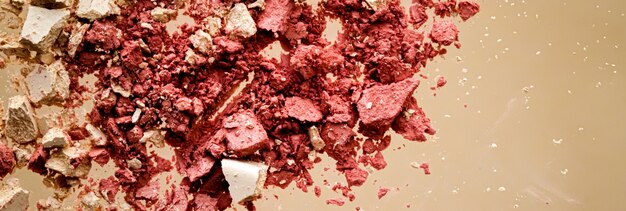 Verpletterde cosmetica minerale organische oogschaduw blush en cosmetische poeder geïsoleerd op gouden achtergrond ...