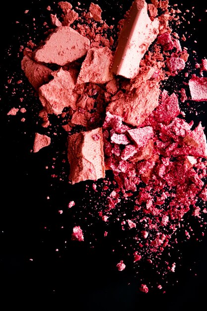 Verpletterde cosmetica minerale organische oogschaduw blush en cosmetische poeder geïsoleerd op zwarte achtergrond m...