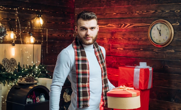 Verrassing voor liefje Prettige kerstdagen en gelukkig nieuwjaar Kerstcadeaus Man modieus knap met geschenkdoos verrassing Man goed verzorgde hipster voor kerstversiering achtergrond