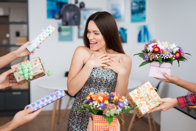 Verrassingsfeest. Meisje omringd door geschenken bloemen.