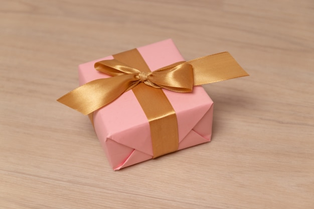 Verrassingsgeschenk of doos verpakt in papier en satijnen lint op een grijze achtergrond. Kan gebruiken voor verjaardag, nieuwjaar, moederdag of vaderdag