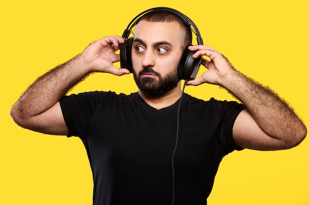 Verrast Arabische muzikant Dj met een baard luistert naar muziekhoofdtelefoons. Internationale DJ-dag