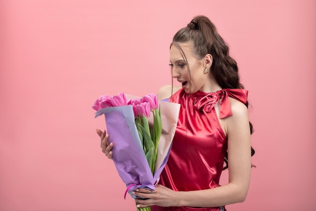 Verrast gelukkige jonge vrouw geschokt om bloemen te ontvangen van een vreemdeling ontving een pakket