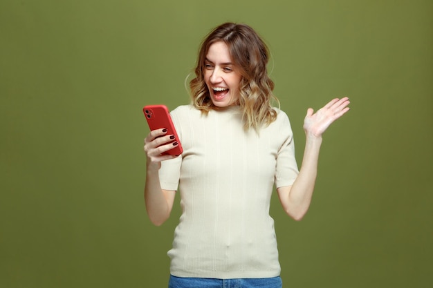 Verrast gelukkige jonge vrouw leest goed nieuws op telefoon win online winkelen promocode of prijs in