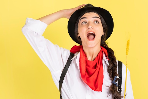 Verrast jonge cowgirl houdt haar handen aan haar hoed Hoge kwaliteit foto