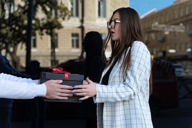 Verrast meisje krijgt cadeau. De jonge vrouw werd verrast.