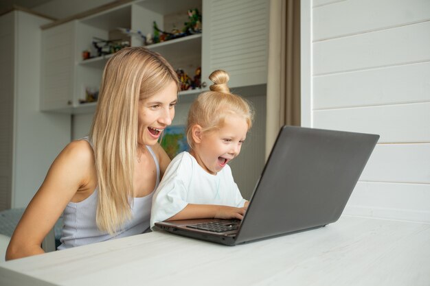 Verrast moeder en dochter zitten thuis op laptop