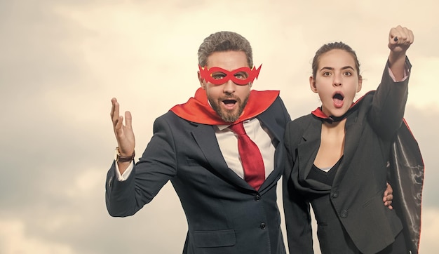 Foto verrast zakenpaar in superheldenpak op hemelachtergrond