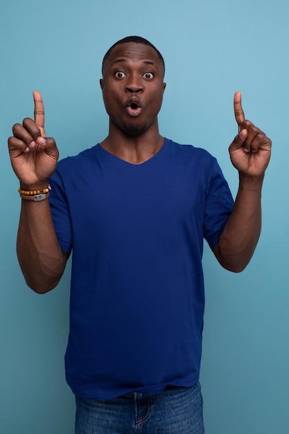 Verraste c Afrikaanse man in casual blauwe t-shirt duimen omhoog