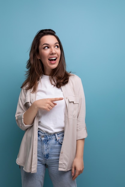 Verraste emotionele donkerbruine vrouw, gekleed in een shirt en spijkerbroek, kijkt weg op een