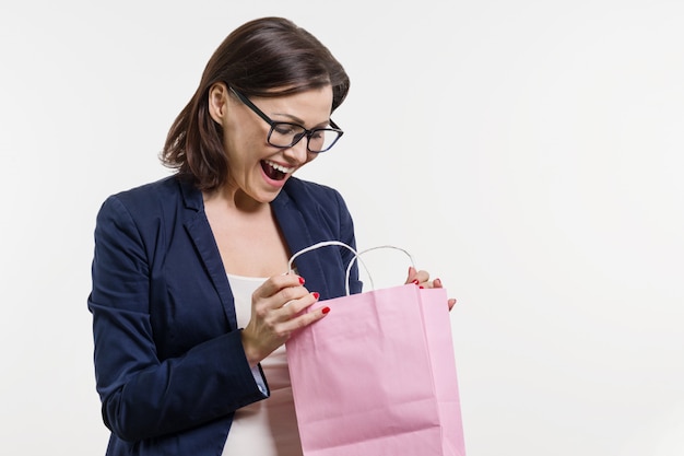 Verraste volwassen vrouw die het winkelen zak kijkt