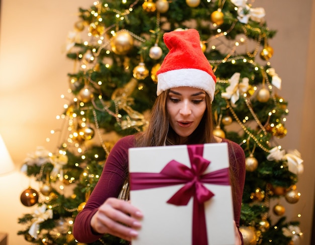 Verraste vrouw die een kerstcadeau opent