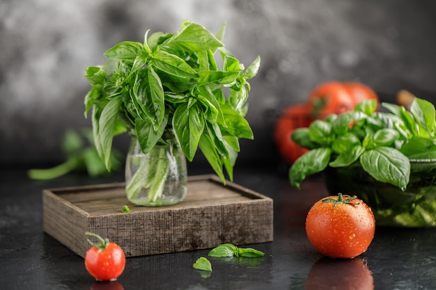 Vers basilicum met tomaten op een steen donkere achtergrond