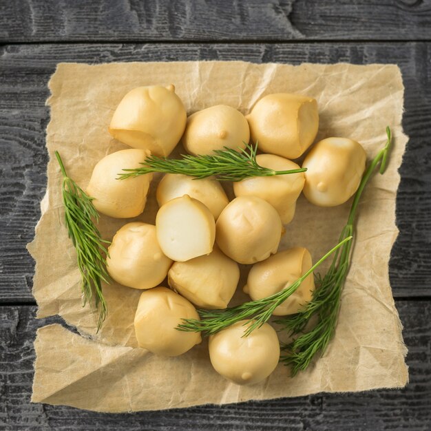 Vers bereide gerookte mozzarellakaas in papier op een houten tafel