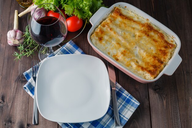 Vers bereide lasagne met ingrediënten op tafel