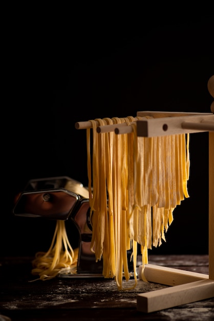 Vers bereide tagliatelle-pasta wordt gedroogd op een houten droger, traditionele Italiaanse keuken