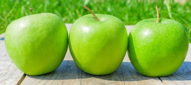 Vers bijgesneden groene appels op houten tafel over groen