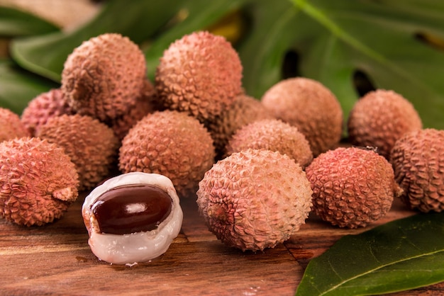 Vers biologisch lychee fruit op bamboemand en oude houten achtergrond, wazige achtergrond selectieve focus.