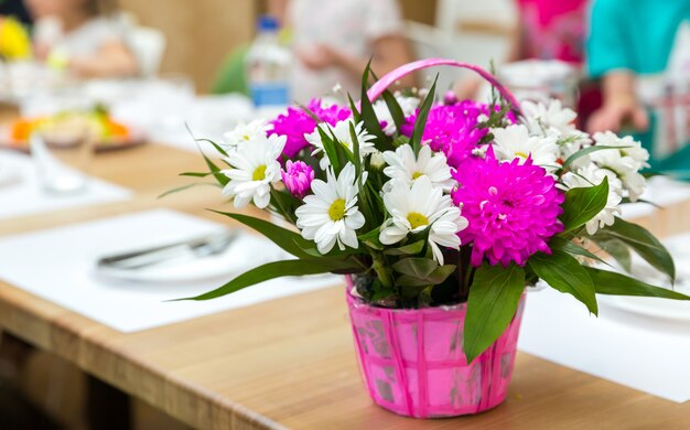 Vers bloemboeket versierd met mand. Floral samenstelling op houten tafel