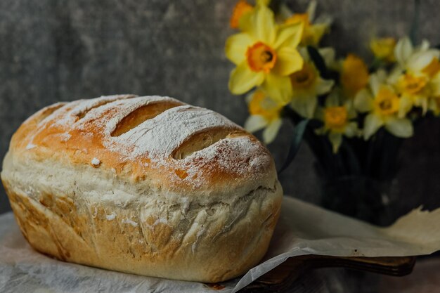 Vers brood alleen uit de oven koelt af op bakpapier bij mooie bloemen