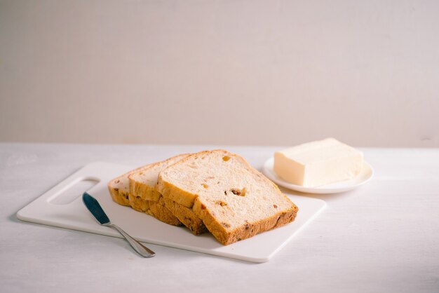 Vers brood en zelfgemaakte boter op witte tafel