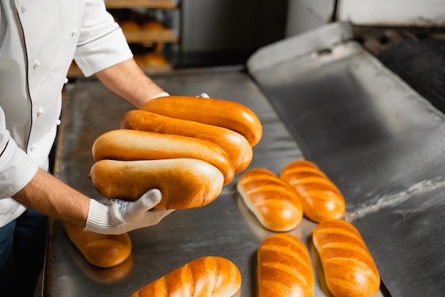 Vers brood in de handen van een bakkersclose-up. Industriële broodproductie