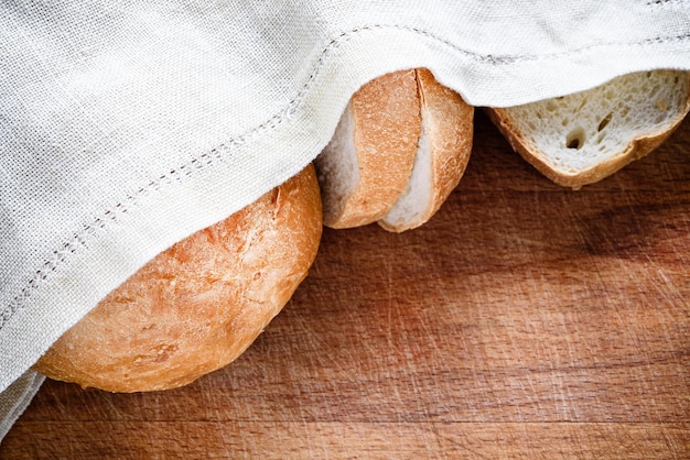 Vers brood onder een linnen servet op een houten Vers brood onder een linnen servet op een houten