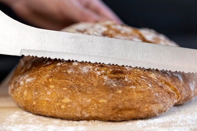 Vers brood op de keukentafel de chef-kok snijdt witbrood Het concept van gezond eten Brood bakken