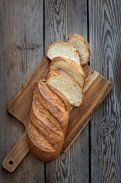 Vers brood op een bruine achtergrond. Traditioneel tarwe vers rustiek gebakken brood, brood.