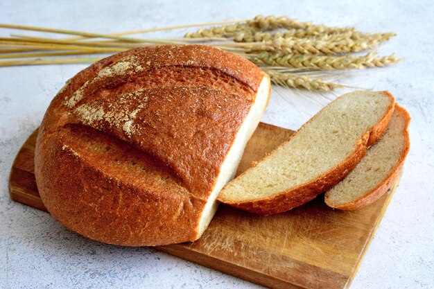 vers brood op snijplank met plakjes en oren van tarwe geïsoleerd, close-up