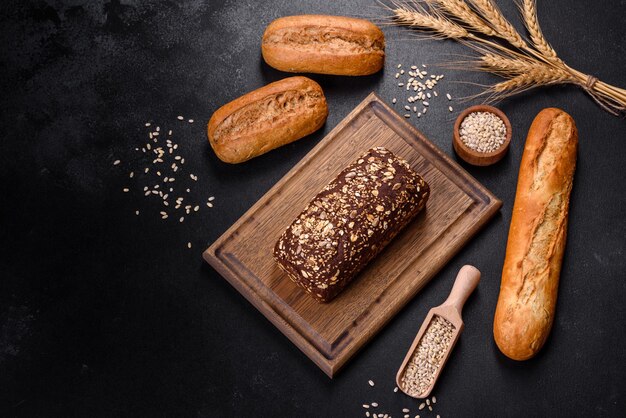 Vers brood op zwarte achtergrond, bovenaanzicht, kopieer ruimte. Huisgemaakt vers gebakken diverse broden van tarwe en roggebrood