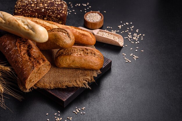 Vers brood op zwarte achtergrond, bovenaanzicht, kopieer ruimte. Huisgemaakt vers gebakken diverse broden van tarwe en roggebrood