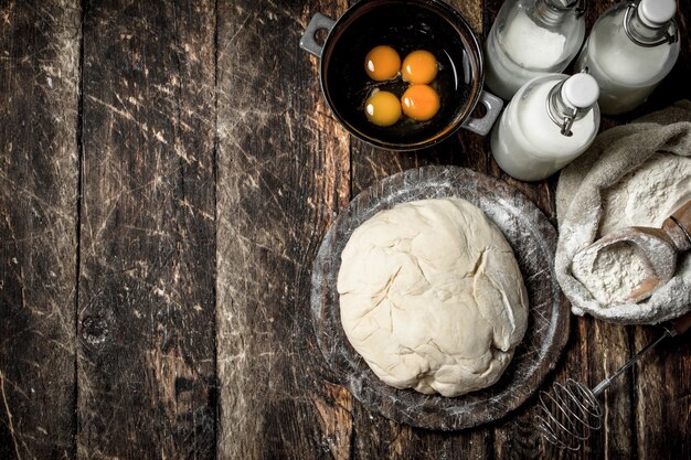 Vers deeg met ingrediënten. op een houten achtergrond.