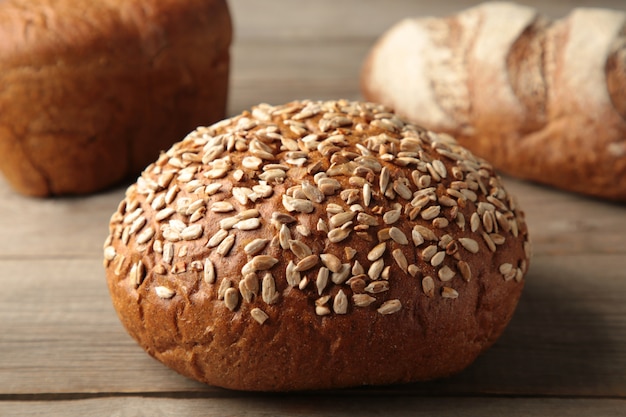 Vers donker brood met aartje van tarwe op grijze houten tafel. Bovenaanzicht