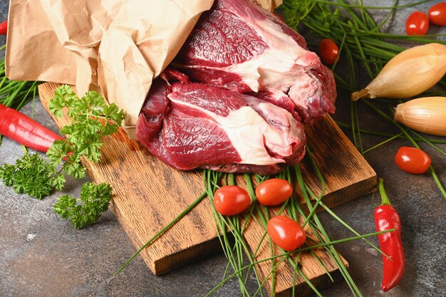 Vers donker vlees met ingrediënten voor het koken op bruine houten besnoeiing