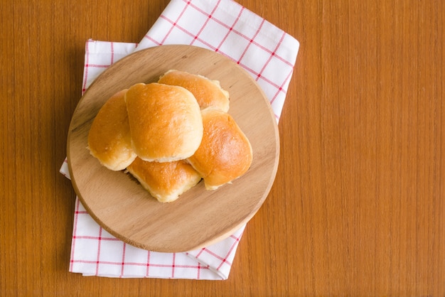 Vers eigengemaakt heerlijk boterbroodjebrood over houten dienblad op rood &amp; wit servet