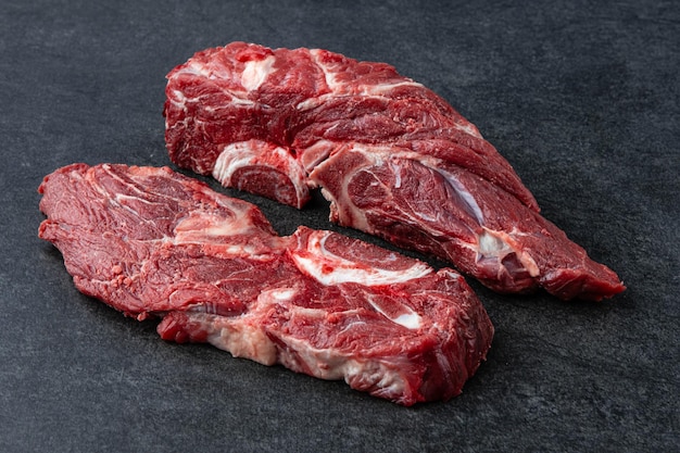 Vers en rauw filetvlees Hele stuk ossenhaas steaks op zwarte stenen tafel achtergrond geen decoratie