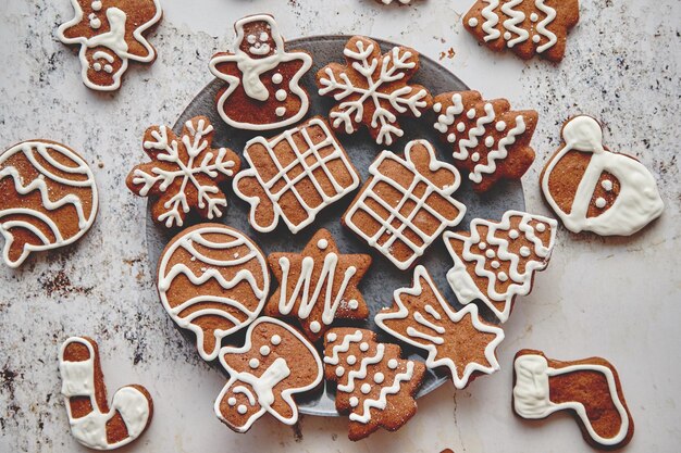 Vers en smakelijk peperkoek kerstkoekjes geplaatst op witte roestige tafel Verschillende vormen Kerstman sneeuwvlok boom cadeau sneeuwpop