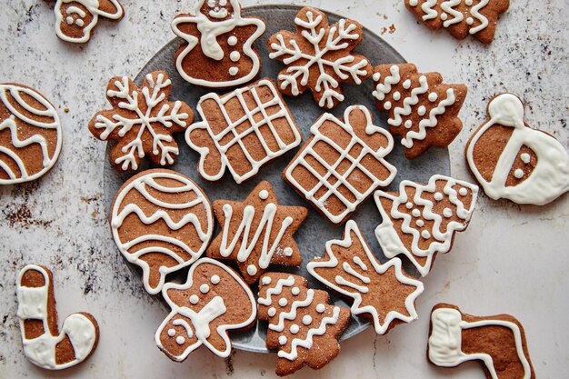Vers en smakelijk peperkoek kerstkoekjes geplaatst op witte roestige tafel Verschillende vormen Kerstman sneeuwvlok boom cadeau sneeuwpop