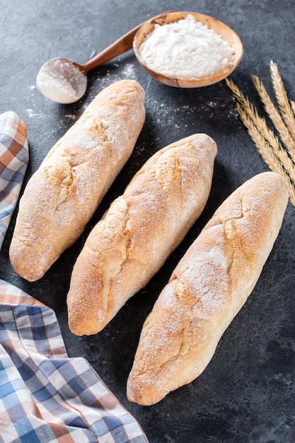 Vers Frans stokbrood brood op donkere achtergrond. Zelfgemaakte Franse stokbrood broden, bovenaanzicht.