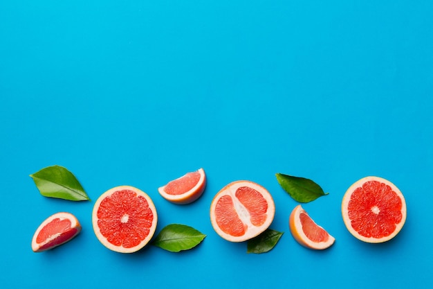 Vers fruit grapefruit met sappige grapefruit plakjes op gekleurde achtergrond bovenaanzicht kopie ruimte creatieve zomer concept helft van citrus in minimale plat lag met kopie ruimte