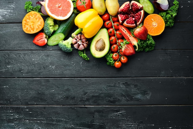 Vers fruit, groenten en bessen Op een zwarte achtergrond Banner Bovenaanzicht Vrije ruimte voor uw tekst