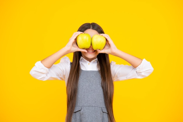 Vers fruit Het tienermeisje houdt appels op gele geïsoleerde studioachtergrond Kindervoeding