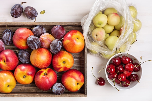 Vers fruit set. Pruimen en nectarines in vak, bovenaanzicht.