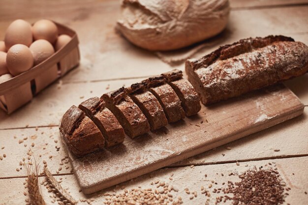 Vers gebakken brood bovenaanzicht van gesneden volkoren brood op donkere ructische houten close-up als achtergrond