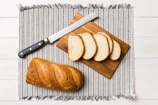 Vers gebakken brood gesneden met mes op een houten plank bovenaanzicht Gesneden brood en mes
